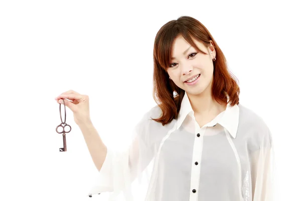 Schöne Japanerin hält einen Schlüssel in ihren Händen — Stockfoto