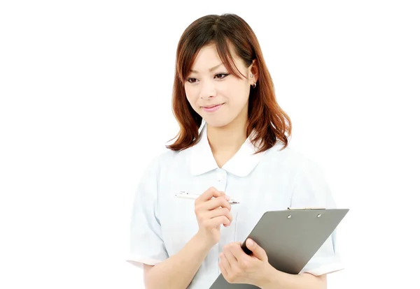 Young female nurse with clipboard — Stock Photo, Image