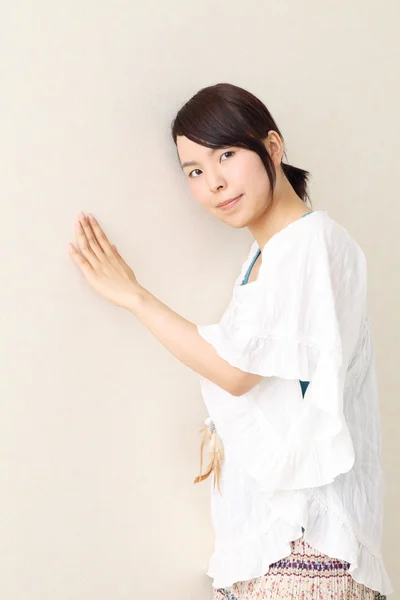 Jovem mulher asiática de pé inclinando-se uma parede — Fotografia de Stock