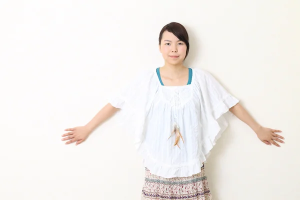 Jonge mooie Aziatische vrouw leunend tegen muur — Stockfoto