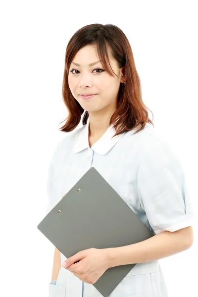 Junge asiatische Krankenschwester in Uniform hält ein Klemmbrett — Stockfoto