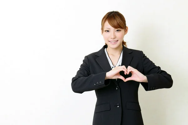 Jovem mulher de negócios feliz fazer a forma do coração por suas mãos — Fotografia de Stock