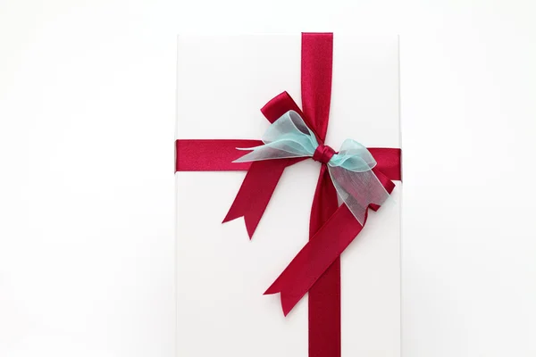 Fehér ajándék doboz piros szalaggal — Stock Fotó