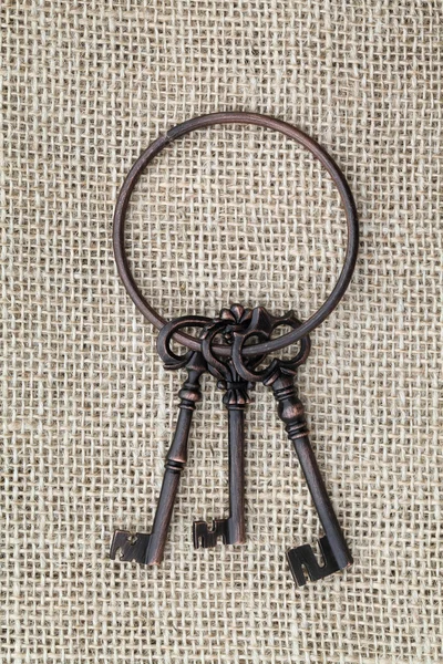 Starý klíč na pytlovina pozadí — Stock fotografie