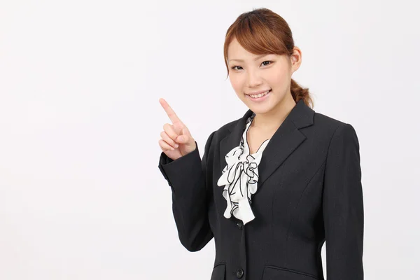 Smiling asian woman rise hand and pointing — Stock Photo, Image