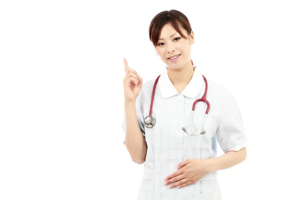 Unga asiatiska kvinnor sjuksköterska pekar — Stockfoto