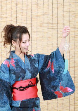 Japanese woman in traditional clothes of Kimono with wind-bell clipart