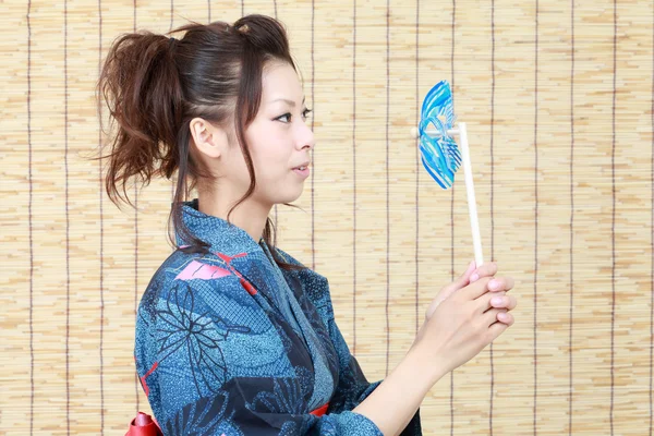 Japanese woman in traditional clothes of kimono with pinwheel — Stock Photo, Image