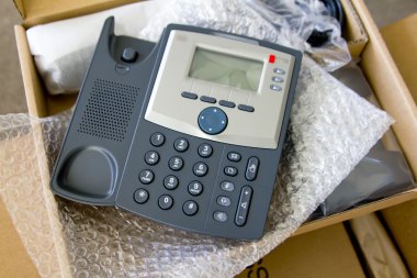 New VoIP phone in package clipart