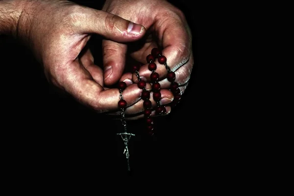 Sacerdote mano tenendo rosario su nero, sguardo drammatico — Foto Stock