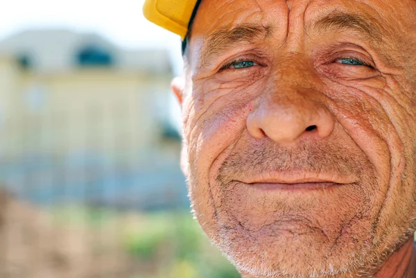 Homem velho enrugado com tampa amarela — Fotografia de Stock