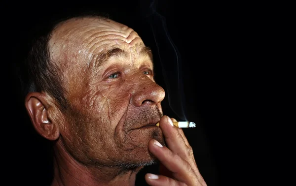 Velho homem enrugado fumando — Fotografia de Stock