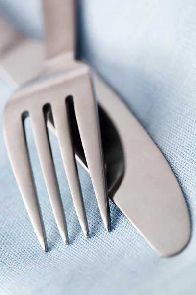 Mes en vork in blauwe linnen — Stockfoto