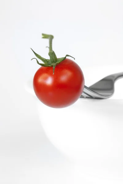 Tomat och gaffel på skål — Stockfoto