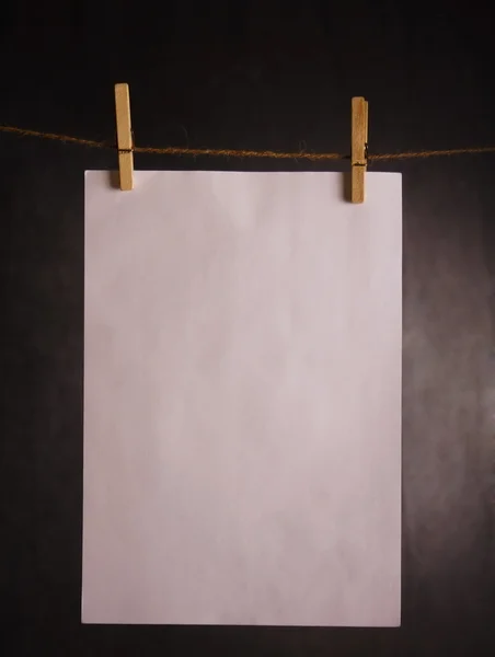 Um pedaço de papel pendurado no cabo — Fotografia de Stock