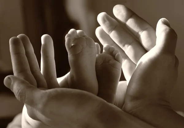 パパの手で赤ちゃんの足 — ストック写真