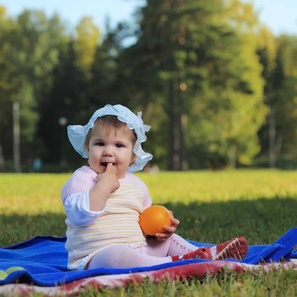 Litle baby sitter på gräsmattan — Stockfoto