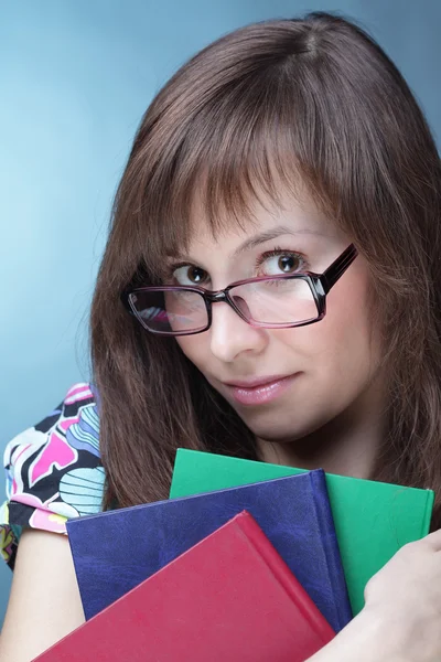 Menina de beleza com livro sobre fundo azul — Fotografia de Stock