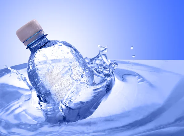Garrafa de plástico em respingo de água — Fotografia de Stock