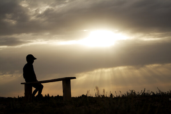 Boy on background of the reflecting sun