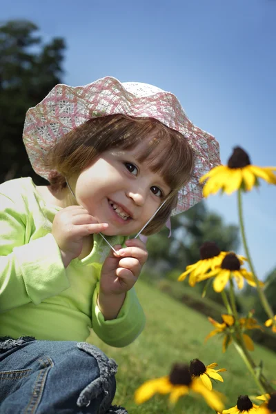 Bebé en el césped de flores — Foto de Stock