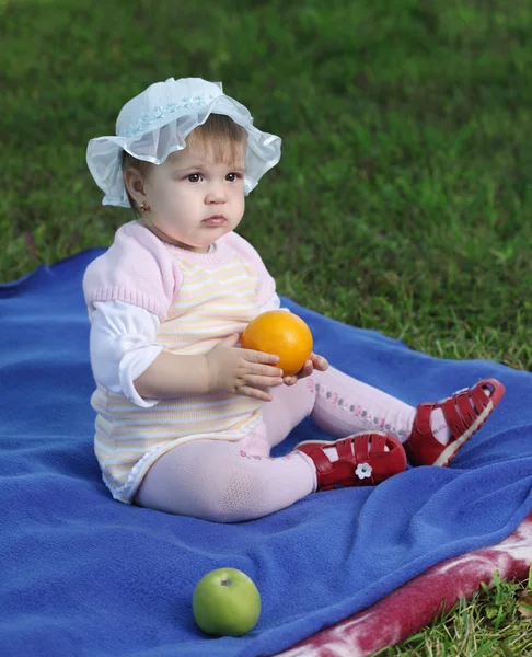 Litle baby sitter på gräsmattan — Stockfoto