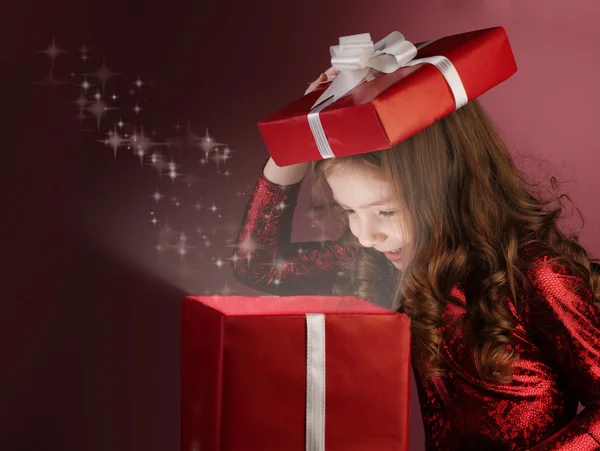 Kleines Mädchen öffnet rote Geschenkschachtel — Stockfoto