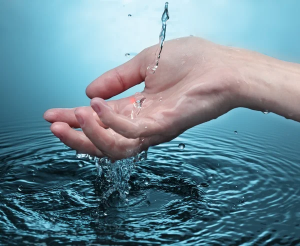 Mulher mão em respingo de água — Fotografia de Stock