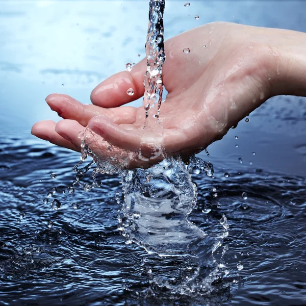 Mulher mão em respingo de água — Fotografia de Stock