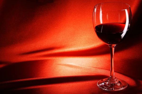 红色背景上的红葡萄酒杯 — 图库照片