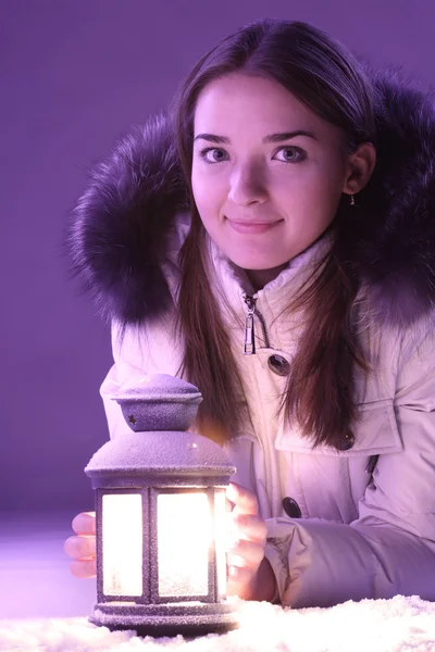 Красивая девушка на зимнем снегу с фонариком — стоковое фото