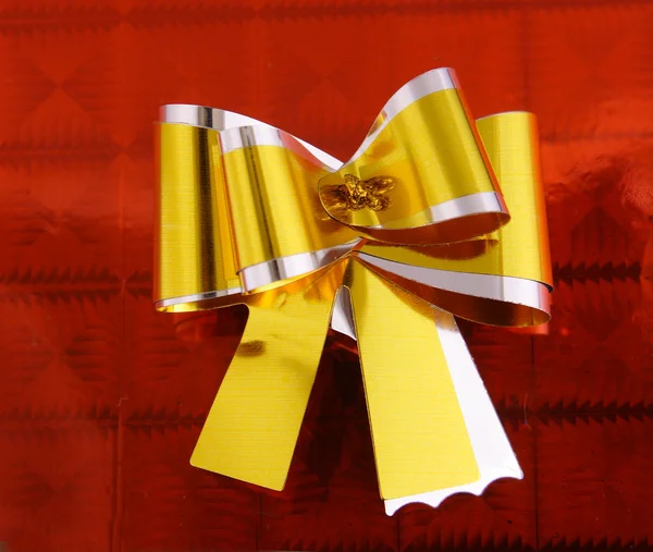 Golden ribbon on red — Stock Photo, Image