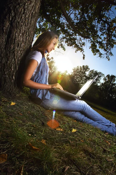 Красуня дівчина з ноутбуком в парку — стокове фото
