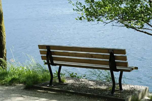 Пустая скамейка на озере — стоковое фото