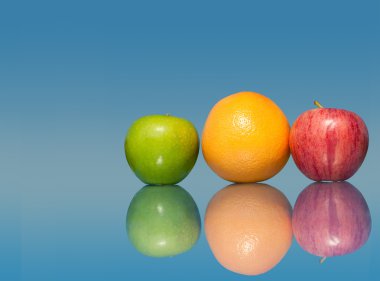 Fresh, colorful fruit on blue background with reflection clipart