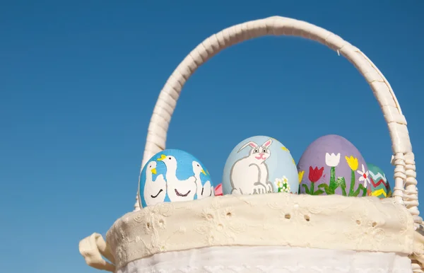 Cesta con huevos de Pascua contra cielo azul claro —  Fotos de Stock