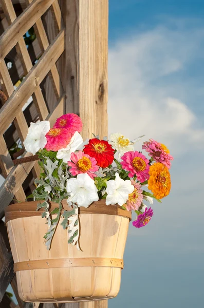 Cesta cheia de flores brilhantes contra a madeira rústica — Fotografia de Stock