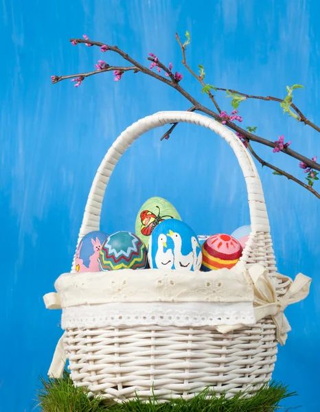 Корзина с разноцветными пасхальными яйцами ручной работы — стоковое фото
