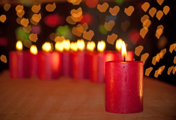 Red Christmas candle burning on a wooden table — Stock Photo, Image