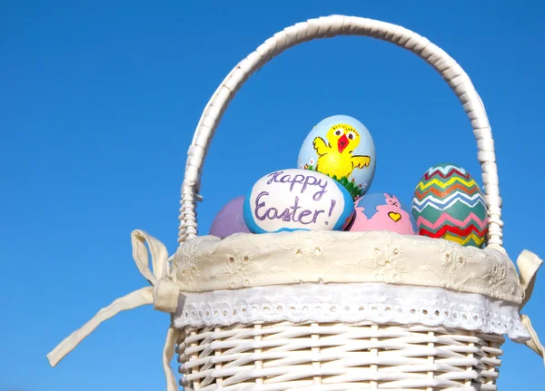 Coloridos huevos de Pascua pintados a mano en una cesta de mimbre —  Fotos de Stock