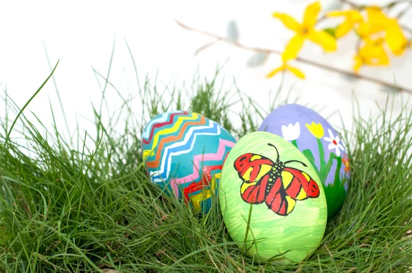 Coloridos huevos de Pascua pintados a mano en hierba verde de primavera —  Fotos de Stock