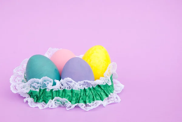 Pastel colored hand painted Easter egg shells nested in delicate lace — Stock Photo, Image