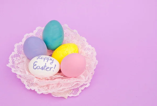 Hand painted pastel colored Easter eggs in a nest made of lace — Stock Photo, Image