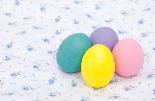 Pastel renkli el boyalı Paskalya yumurta beyaz bir bez üzerinde — Stok fotoğraf