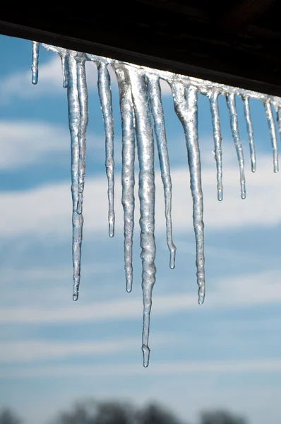 Gorgeous melting icicles against partly cloudy skies — Stock Photo, Image
