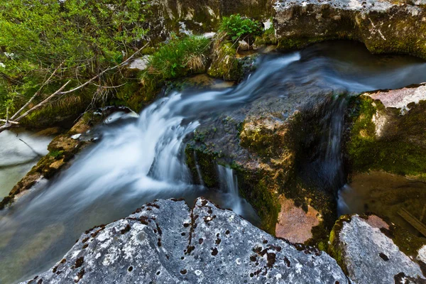 Вода лениво течет между скалами в реке — стоковое фото