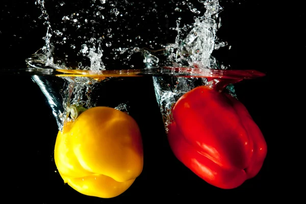 Salpicadura de agua de pimiento rojo y amarillo —  Fotos de Stock