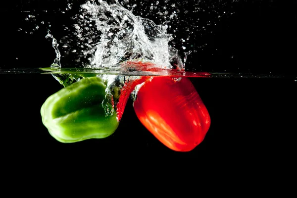 Kırmızı ve yeşil biber su sıçrama — Stok fotoğraf