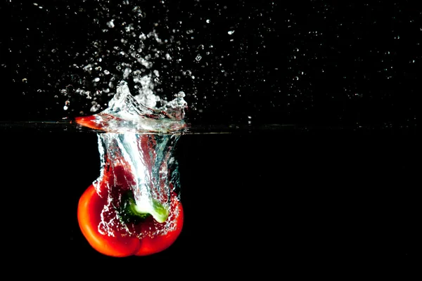 Plusk wody czerwonego pieprzu — Zdjęcie stockowe