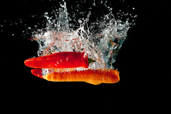 Plusk wody chili i marchewki — Zdjęcie stockowe
